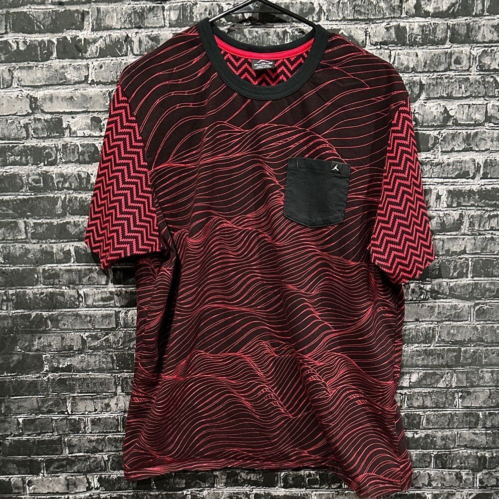 Jordan men's tee in red and black with a unique all-over pattern and a pocket.